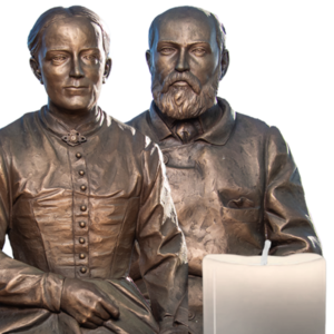 Bronze statue of Saints Louis and Zelie Martin with a candle
